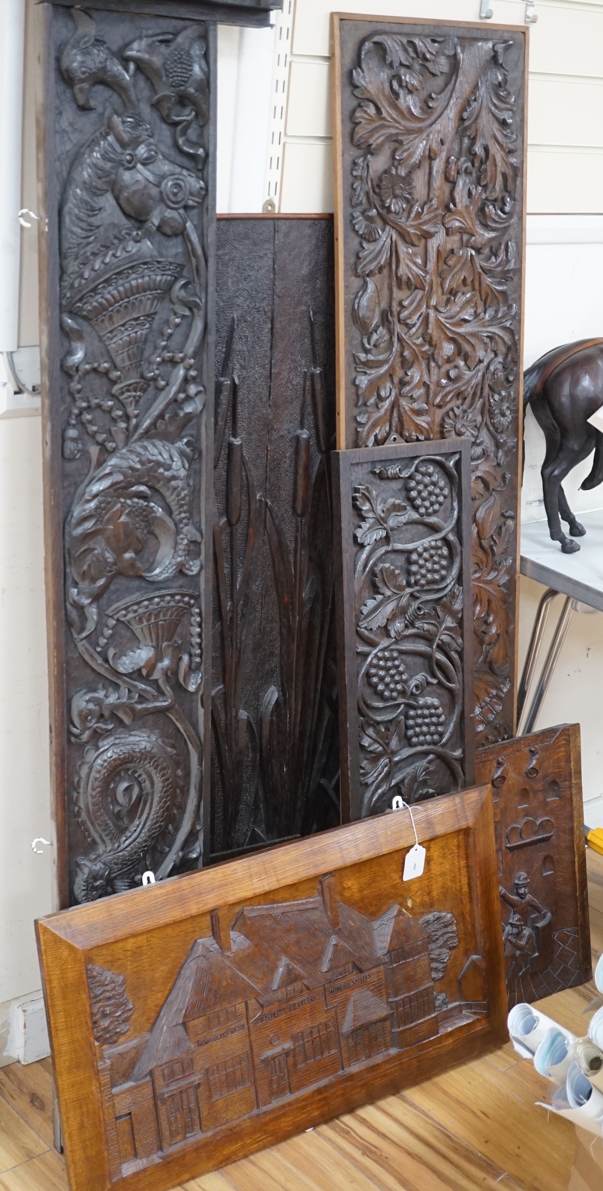 Seven assorted carved wooden panels, widest 166 cms